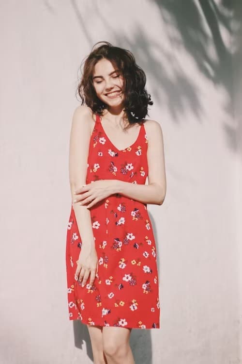 Woman wearing an off-white oversized linen shirt dress belted at the waist outdoors